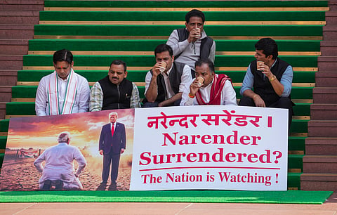Opposition MPs who were suspended by the Speaker, protest outside the Parliament on Feb 10, 2026, with a poster saying "Narender Surrendered?" indicating that Prime Minister Narendra Modi had "surrendered" before US President Donald Trump with the India-US trade deal. 