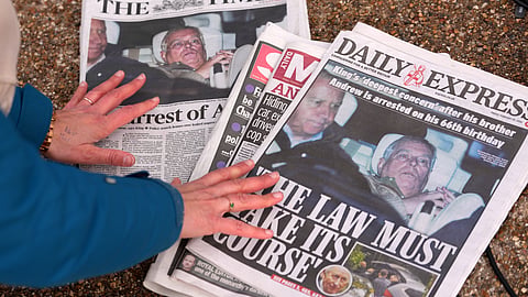 A journalist looks at today's newspaper front pages in London, Friday, Feb. 20, 2026, after Andrew Mountbatten-Windsor was arrested and held for hours by British police on suspicion of misconduct in public office related to his links to Jeffrey Epstein.