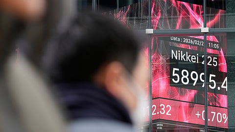 People walk near an electronic stock board showing Japan's Nikkei index at a securities firm Thursday, Feb. 26, 2026, in Tokyo. 