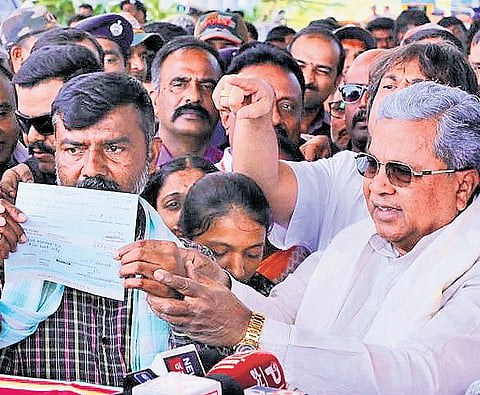 Chief Minister Siddaramaiah hands over Rs 15 lakh compensation to the grieving parents of 15-year-old Sanketh in Shivamogga on Sunday  