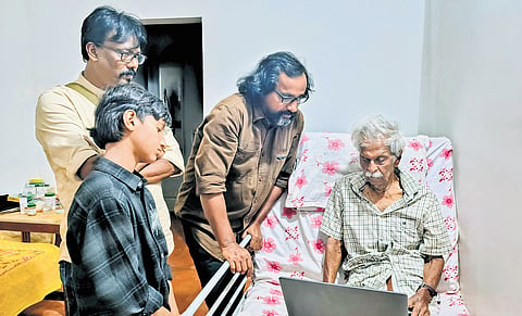 The members of Chithrakar Kerala showing Kanayi Kunhiraman the paintings on him displayed at 
the exhibition