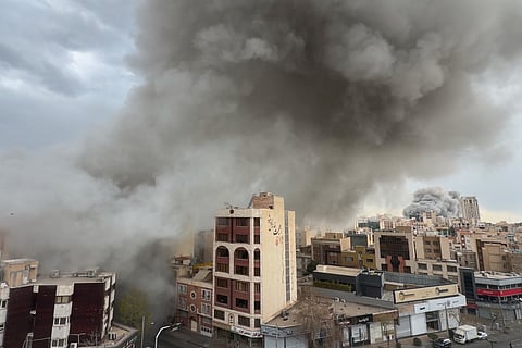 Plumes of smoke from two simultaneous strikes rise over Tehran, Iran, Monday, March 2, 2026.