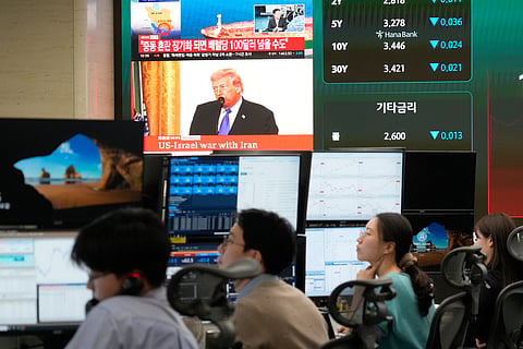 U.S. President Donald Trump is seen on a screen as traders work at the foreign exchange dealing room of the Hana Bank headquarters in Seoul, South Korea, Tuesday, March 3, 2026.