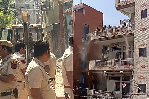 This file image shows Police officials at the site, after Municipal Corporation of Delhi, carried out a demolition drive and razed illegal portions of a house linked to one of the accused in the Uttam Nagar Holi clash case