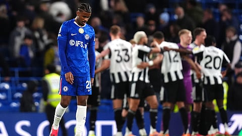 Chelsea's Jorrel Hato looks dejected as Newcastle United players celebrate victory following the Premier League match between Chelsea and Newcastle, in London, Saturday March 14, 2026. 