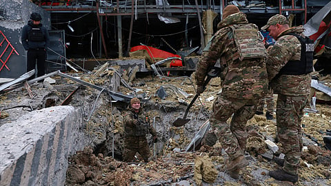 Sappers examine the site of a Russian missile strike which hit a post office storehouse in Zaporizhzhia, Ukraine, Tuesday, March 17, 2026. 