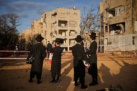 People look at residential buildings heavily damaged by an Iranian missile strike in Arad, southern Israel, Sunday, March 22, 2026. 
