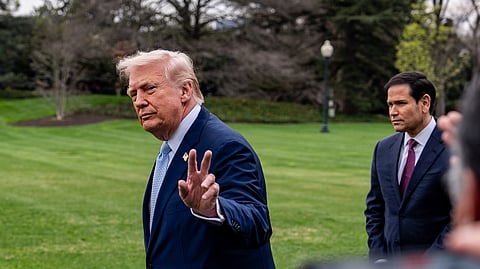 President Donald Trump waves, with Secretary of State Marco Rubio, before departing on Marine One from the South Lawn of the White House, Friday, March 20, 2026, in Washington. 
