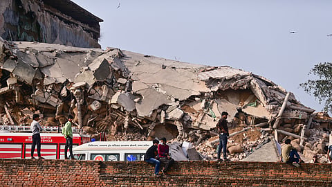 People gather as a rescue operation is underway after a cold storage building collapsed, at Phaphamau, in Prayagraj district, Uttar Pradesh, Monday, March 23, 2026. 