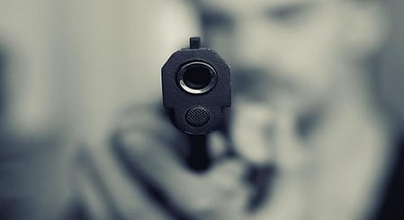 The two men then allegedly threatened the owner with a gun and fired four rounds inside the shop.
