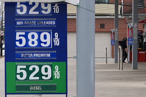 Gas prices are displayed as a man checks gas prices before he fills up his vehicle's gas tank at a gas station in Chicago, Wednesday, March 25, 2026. 