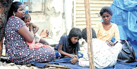 A woman with her children on a roadside pavement
at George Town in Chennai 