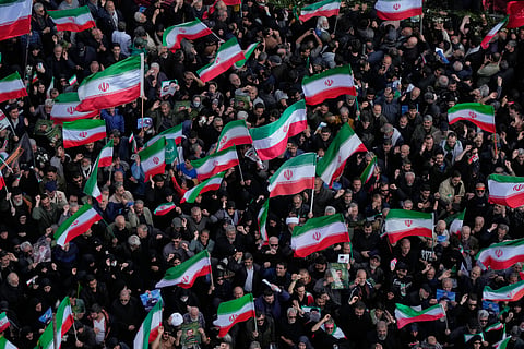 Mourners wave Iranian flags in Tehran, Iran, Wednesday, April 1, 2026, as they gather during a funeral procession for Alireza Tangsiri, head of Iran's Islamic Revolutionary Guard Corps Navy, and others killed in Israeli strikes in late March. 
