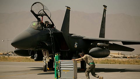 A U.S. Air Force airman pushes a cart past an F-15E Strike Eagle at Bagram Air Field in Afghanistan on Oct. 17, 2009. 