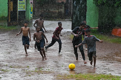 Boys playing in rain at Rasulgarh as incessant rain following norwester lashes Bhubaneswar on Sunday. 