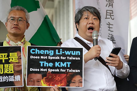 A protester delivers a speech as Taiwan's main opposition Nationalist Party, or Kuomintang (KMT) chairperson Cheng Li-wun leaves for China, outside of Taipei Songshan Airport in Taipei, Taiwan, Tuesday, April 7, 2026. 