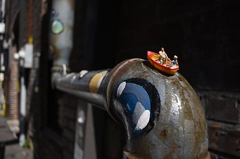 Two figurines canoe down a painted pipe at the Hattiesburg Pocket Museum.