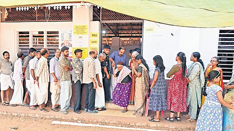 People wait to cast their votes in the assembly elections at Perambra Koothali AUP School.