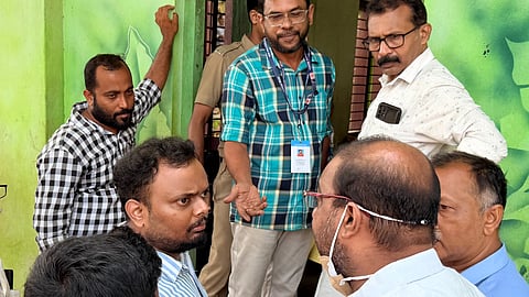 Party workers engaged in an argument with polling officials as voter Saji S (extreme left) looks on. 