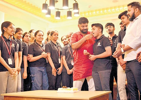 Who scored 587/600 in the II PU exams; Chikkaballapur MLA Pradeep Eshwar gives a piece of cake to PU topper Likith NR as he celebrates securing 595/600 and fourth rank in the state at Parishrama PU College 