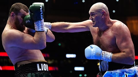 Boxer Tyson Fury, right, punches Arslanbek Makhmudov during a heavyweight bout at Tottenham Hotspur Stadium in London, Saturday, April 11, 2026. 