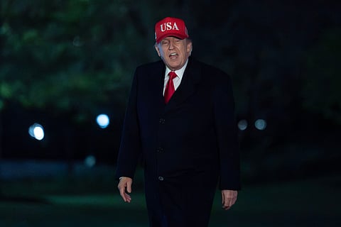 President Donald Trump talks to reporters as he walks on the South Lawn upon his arrival to the White House, Sunday, April 12, 2026, in Washington. 