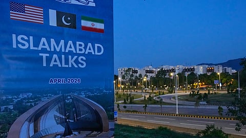 A billboard of the US-Iran talks is seen near the Serena Hotel, the venue for the official meeting between both nations, in Islamabad, Pakistan, Sunday, April 12, 2026.