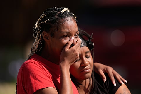 People comfort each other outside the scene of a mass shooting, Sunday, April 19, 2026, in Shreveport, La.