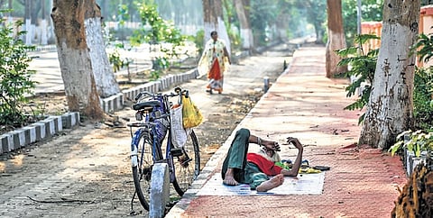 A man takes rest under a tree shade to escape the afternoon heat, at Patel Marg in Bhubaneswar on Sunday 