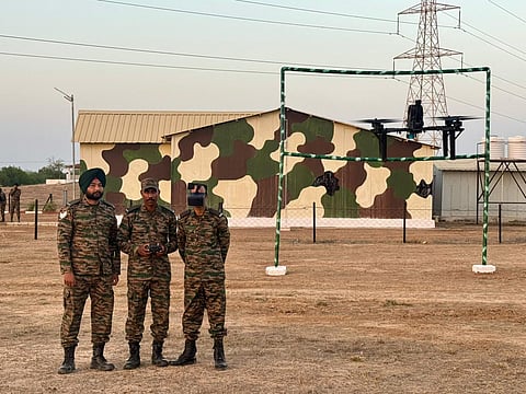Soldiers operate an FPV drone through an obstacle course during training at an Army drone lab
