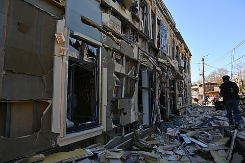 A person walks near residential houses damaged by a Russian strike in Odesa, Ukraine, Monday, April 27, 2026. 