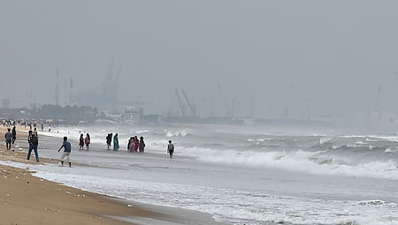 People venture close to the turbulent sea at Marina Beach.