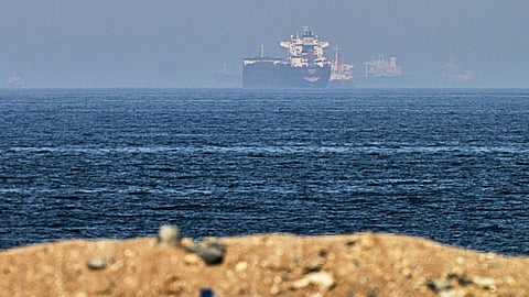 Cargo ships are seen at sea near the Strait of Hormuz, as viewed from a rocky shoreline near Khor Fakkan, United Arab Emirates, Friday, May 1, 2026. 