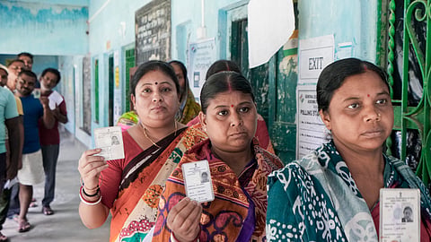 Voters show their identity cards as they wait in a queue to cast their votes at a polling station during a repoll ordered by the Election Commission in  South 24 Parganas district.
