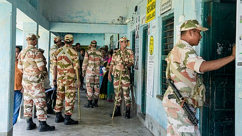 Security personnel stand guard at a polling station.