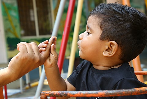 A boy at his mother's inked finger after she cast her vote at St Vincent LP School, Palliyakkal, Chathanad in Kochi.