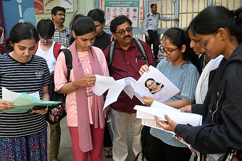 Candidates and parents at the Examination centre checking documents before appearing for the NEET Exam at Basavanagudi in Bengaluru 