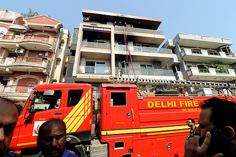A fire brigade at the four-storey residential building in the Vivek Vihar area after a massive fire breaks out resulting in nine deaths and some injuries, in New Delhi on Sunday