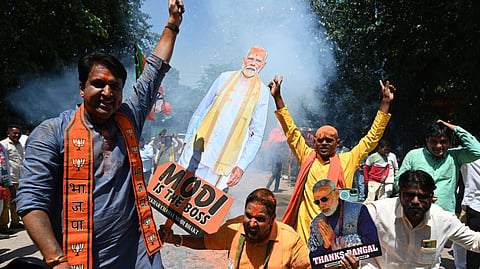 BJP supporters celebrate the party's victory in West Bengal, Assam, and Puducherry, outside the BJP headquarters, in New Delhi on Monday.
