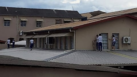 Students of Instituto Sao Jose school take cover on the roof while a teenager invades the school.