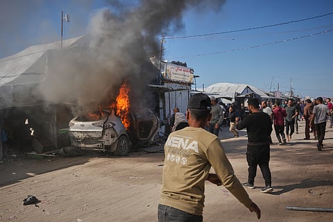 Palestinians gather around a vehicle struck by an Israeli airstrike in Khan Younis, southern Gaza Strip, Wednesday, May 6, 2026.