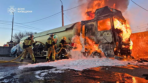 In this photo, provided by the Ukrainian Emergency Service, emergency services personnel work to extinguish a fire a vehicle following a Russian drone attack in Kyiv region, Ukraine, Tuesday, May 5, 2026.
