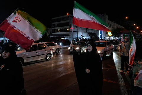 Women hold Iranian flags for a pro-government campaign in downtown Tehran, Iran, Friday, May 8, 2026. 