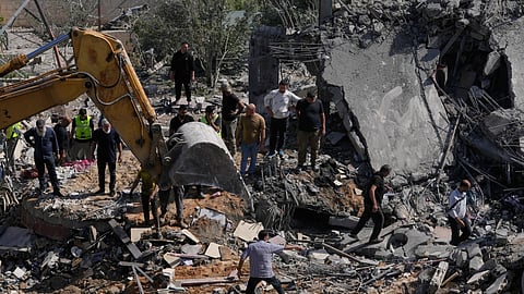 Rescue workers search for survivors using heavy machinery in the rubble of houses damaged by an Israeli airstrike in the village of Saksakieh, south Lebanon, Saturday, May 9, 2026. 