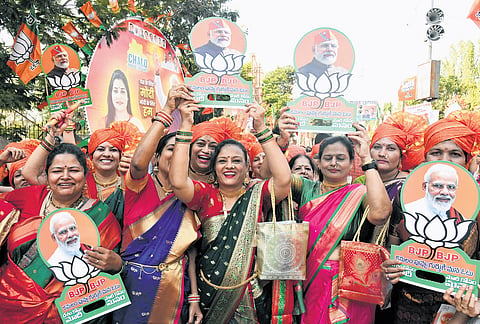 BJP supporters carry Modi pictures as they arrive at the Parade Ground ahead of the public meeting addressed by Prime Minister Narendra Modi 
