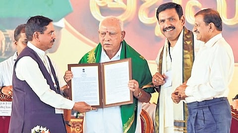 Union Minister Pralhad Joshi presents BJP leader BS Yediyurappa with a framed letter sent by Prime Minister Narendra Modi on Saturday.