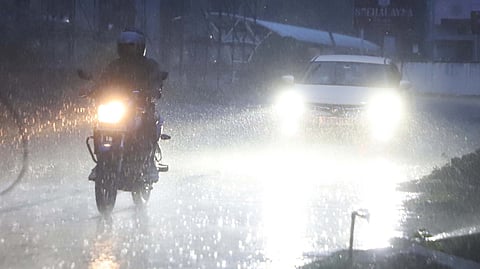 Motorists passing Podanur to Ramanathapuram road during sudden rain in Coimbatore on Saturday evening.