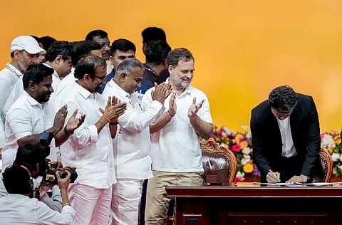 Newly-elected Tamil Nadu Chief Minister and Tamilaga Vettri Kazhagam (TVK) chief C Joseph Vijay signs documents during the TVK cabinet's swearing-in ceremony, at Jawaharlal Nehru Stadium.