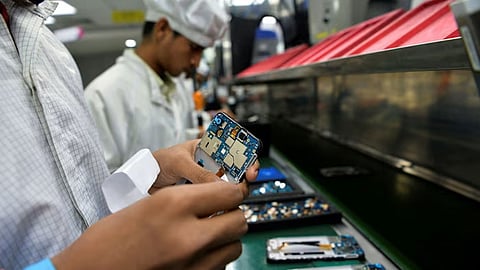 Workers assemble mobile phones at a phone manufacturing factory in Noida