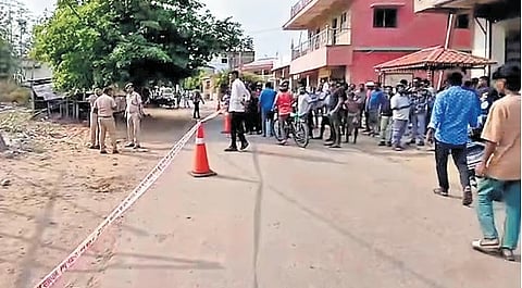 Police and locals at the crime scene in Belpahar on Monday.